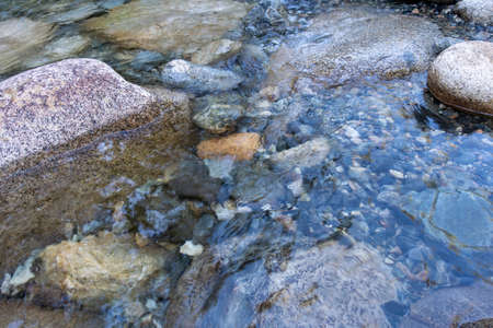 A closeup shot of rocks in a stream with a blurred background