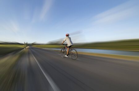 A man is cycling bicycle moving forward on the roadの写真素材
