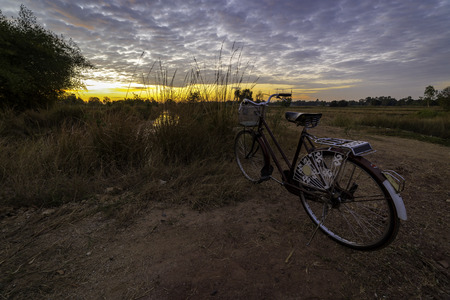 Vintage bicycle parking on local road in Thailand during morning sunriseの写真素材