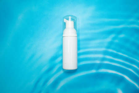 white cosmetic container on blue backgroundの写真素材