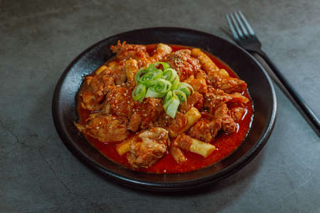 Korean food Spicy Stir-fried Chicken tteokbokki dish on black plateの写真素材