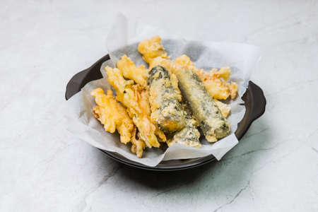 Deep-fried Laver Roll, Deep-fried Squid snack on a black plateの写真素材