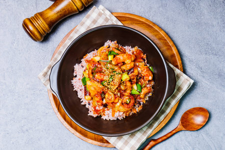 Nakjideopbap, Korean style spicy stir-fried octopus over rice : This dish is made by stir-frying sliced onion and carrots along with sauce over high heat in an oiled pan. Bite-sized pieces of octopus are then added to the half-cooked vegetables. It is served with cooked rice.の写真素材