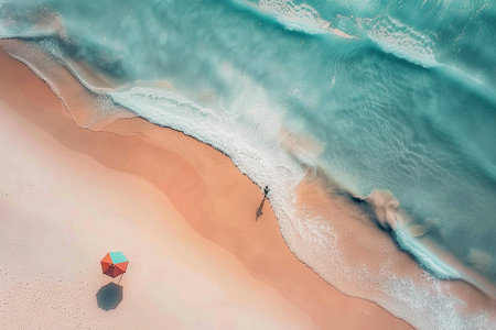 Aerial view of a person standing on a white sandy beach, holding a colorful umbrella with clear blue water and a long exposure effect.の素材
