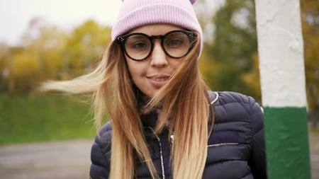 Stylish hipster female turns around the bar gate and smiles