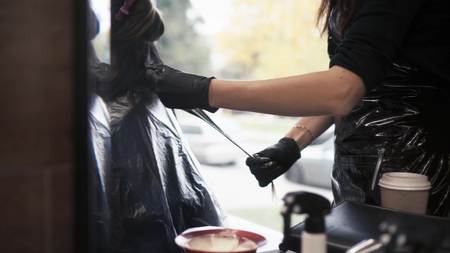 The hairdresser paints the hair of a woman with a tassel. Close-upの写真素材