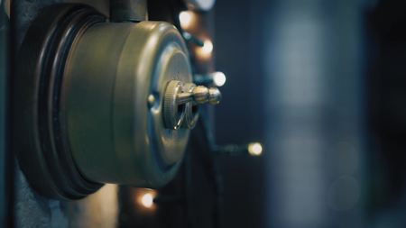 Woman with beautiful pink nail polish turns down the light at home on aenous vintage switch. Closeup viewの写真素材