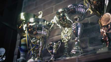 Closeup view on a stand with gold and silver medals, awards and champion cupsの写真素材