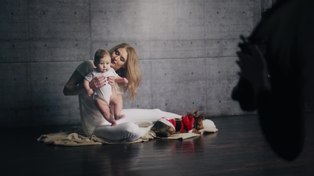 Happy beautiful woman with her little kid and their dog are taking photos in the sdudioの写真素材