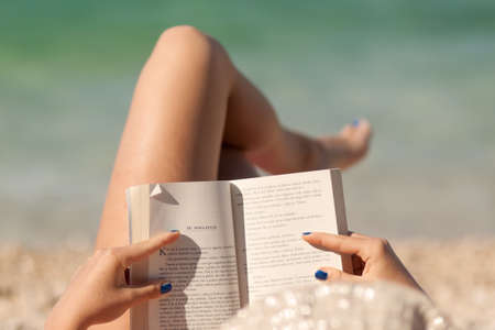 leisure young girl reading a book at beach