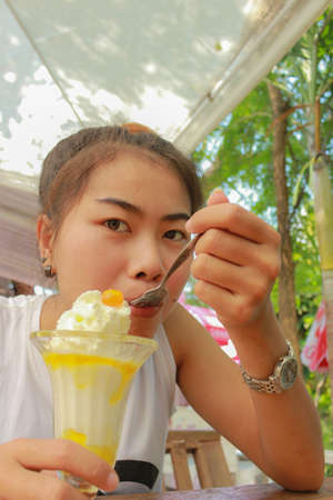 Portrait of young asia woman happy eating ice-cream, outdoor