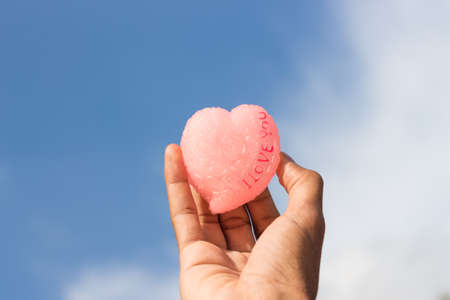 hand hold heart love on blue skyの写真素材