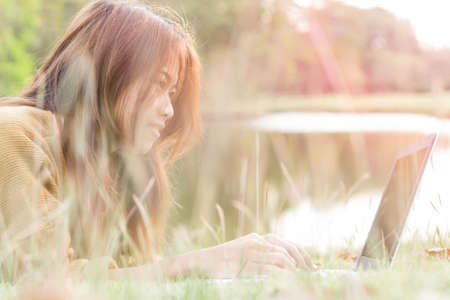 women smile feel happy use laptop computer outdoorの写真素材