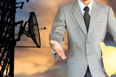 businessman with handshake to cooperation and silhouette satellite communication tower backgroundの写真素材