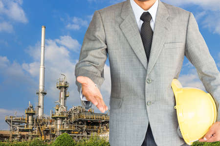 businessman with handshake to cooperation and oil refinery backgroundの写真素材
