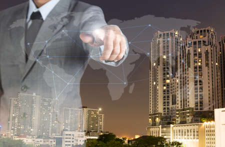 double exposure business man with finger world network and real estate backgroundの写真素材
