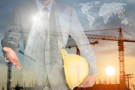 businessman with handshake to cooperation and construction building background