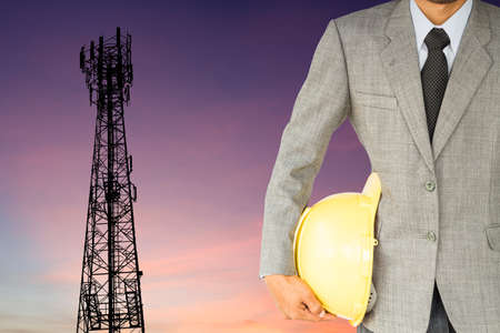 businessman engineer and telecommunication tower at sunset backgroundの写真素材