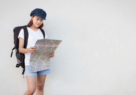 young women carry bag and looking map for travelの写真素材