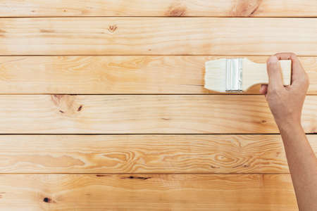 hand painting brush clear lacquer on wood surfaceの写真素材