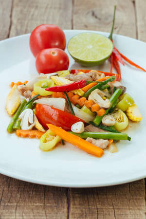 Stir fry vegetables in white dish on wood backgroundの写真素材