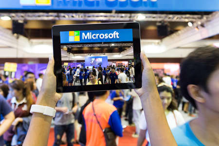 Bangkok thailand - october 03: hand use tablet capture crowd in thailand mobile expo event on october 03, 2015のeditorial素材