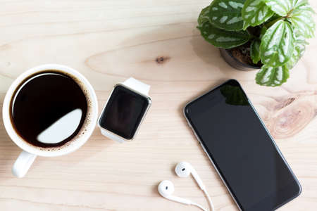 phone and hand watch on wood desk top viewの写真素材
