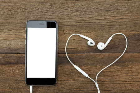 phone white screen with headphone on wood table