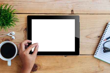 hand using mockup tablet on wood desk white display with clipping path screen easy add image