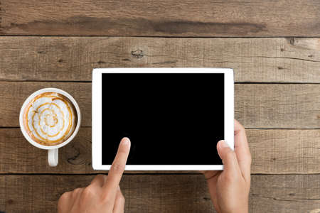 hand using mock up tablet on wood deskの写真素材