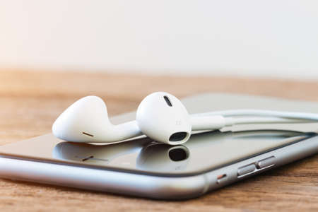 closeup phone and headphone device on tableの写真素材