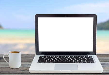 laptop computer and coffee cup front angle on beach viewのeditorial素材