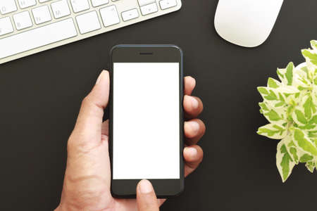 hand hold phone white screen display, close-up business man touch on new smart phone modern technology lifestyleの写真素材