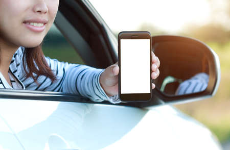 close-up phone in woman hand showing blank screen sitting in car
