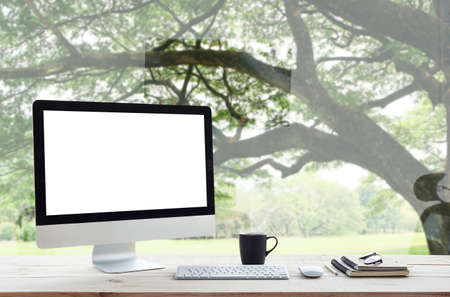 desktop computer on work table and nature backgroundの写真素材