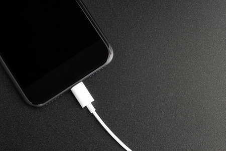 phone connecting usb port on black background top viewの写真素材