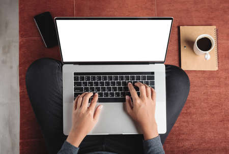 top view person using laptop computer on sofa inside homeの写真素材