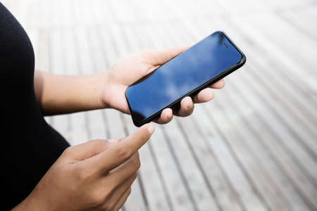 close-up on woman hand using phone outdoor lifestyleの写真素材