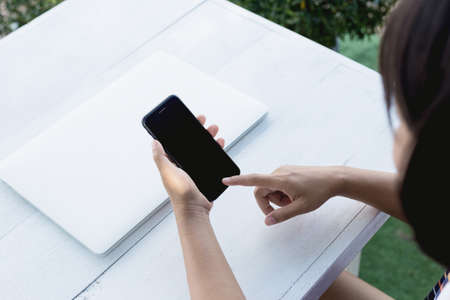 closeup woman hand using phone on table