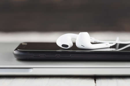 close-up phone and headphone stack on laptop computer front view