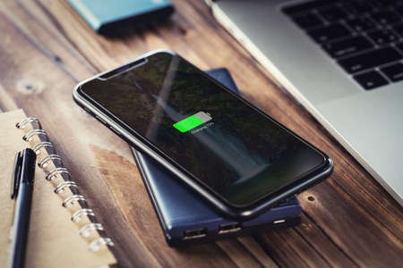 black smart phone charging on external wireless charger