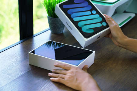 BANGKOK, THAILAND - OCTOBER 1, 2021: Close up hand opening box of new Ipad mini gen 6 order from Apple store onlineのeditorial素材