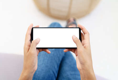 hand using cell phone in horizontal white screen displayの写真素材