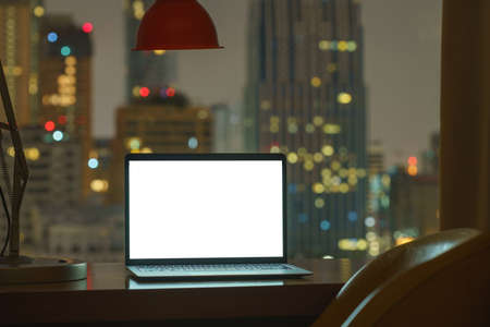 laptop computer on table white display see through city on night backgroundの写真素材