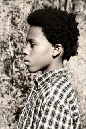 portrait of a serious boy out in nature during autumnの写真素材