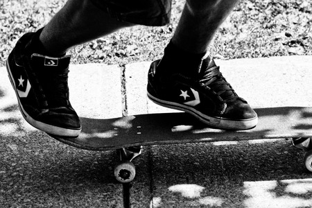 teen wearing converse skate shoes on skateboard ready for actionのeditorial素材