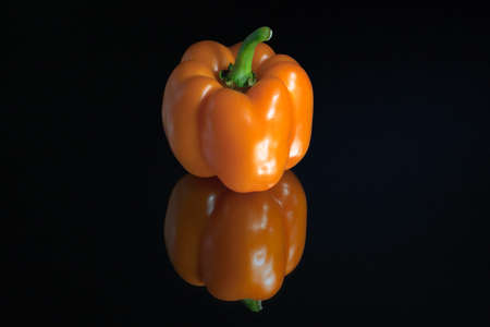 Vegetables. Orange peppers on a black background.の写真素材