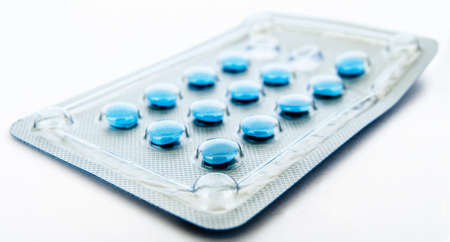 Blue pills in blister isolated on whiteの写真素材