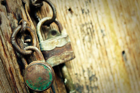 Old padlocks on an old wooden doorの写真素材