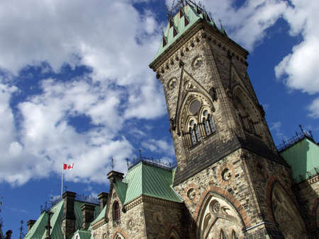 A Gothic tower stands against a partly cloudy sky at the Canadian parliament in Ottawa.の写真素材